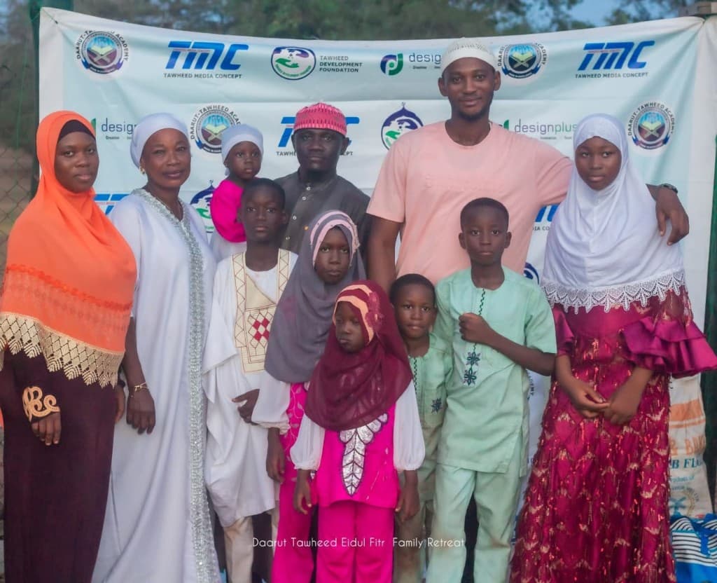 Family group photo at the Daarut Tawheed Eidul Fitr Family Retreat banner