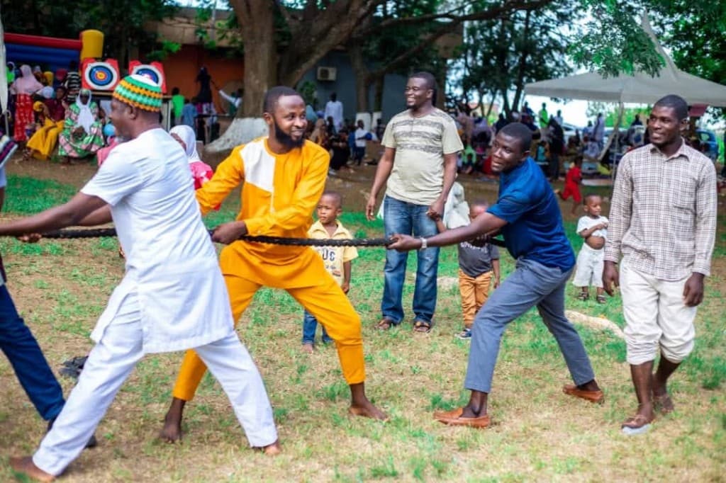 Community members playing tug of war at a DATEX family retreat